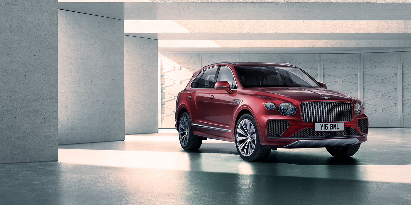 Bentley Surrey Bentley Bentayga Atelier Edition SUV in Rubino Red paint front three quarter against textured concrete wall