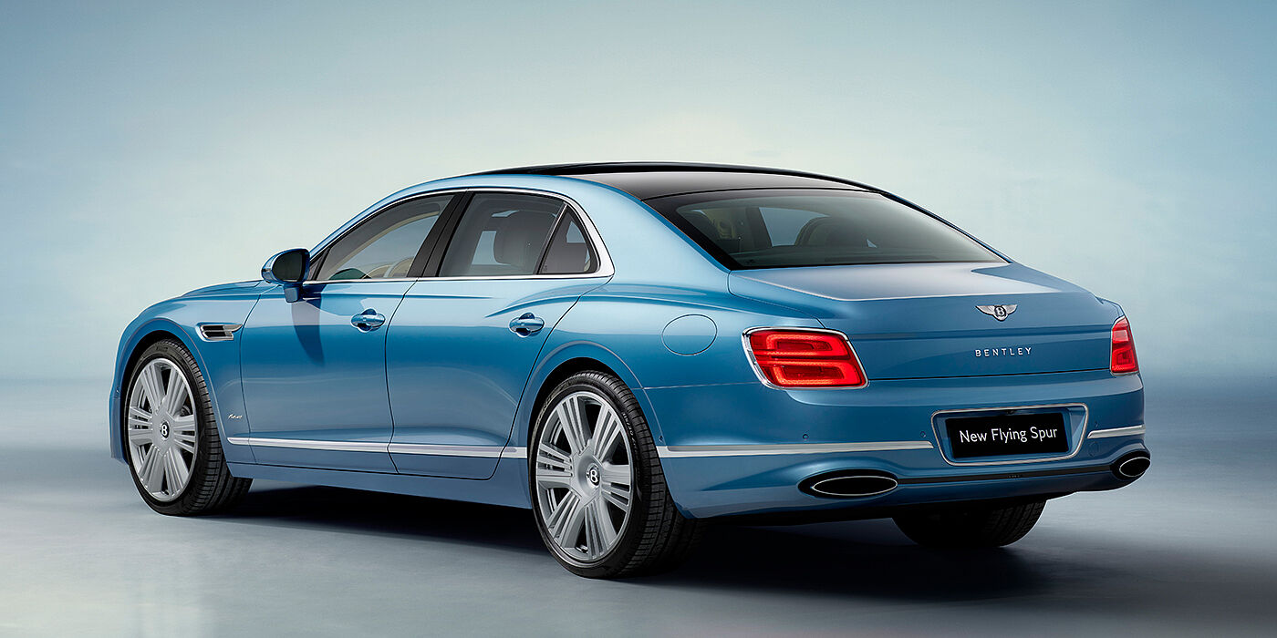 Bentley Surrey New Bentley Flying Spur Azure sedan rear view in Light windsor blue by Mulliner paint with 22 inch Azure wheels and chrome exterior details