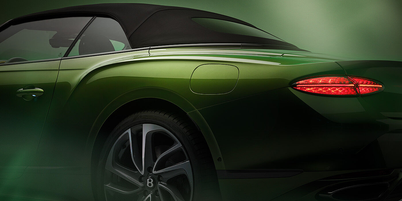 Bentley Surrey Bentley New Continental GTC Speed rear haunch and tail lamp in Tourmaline Green paint and dark tint brightware with black hood up and illuminated head lamps