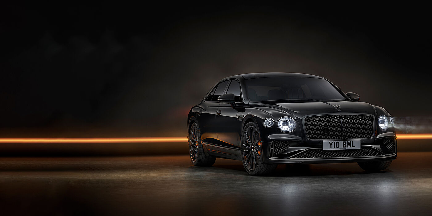 Bentley Surrey Bentley Flying Spur Black Edition sedan in Black Crystal paint against a dark grey and copper coloured background