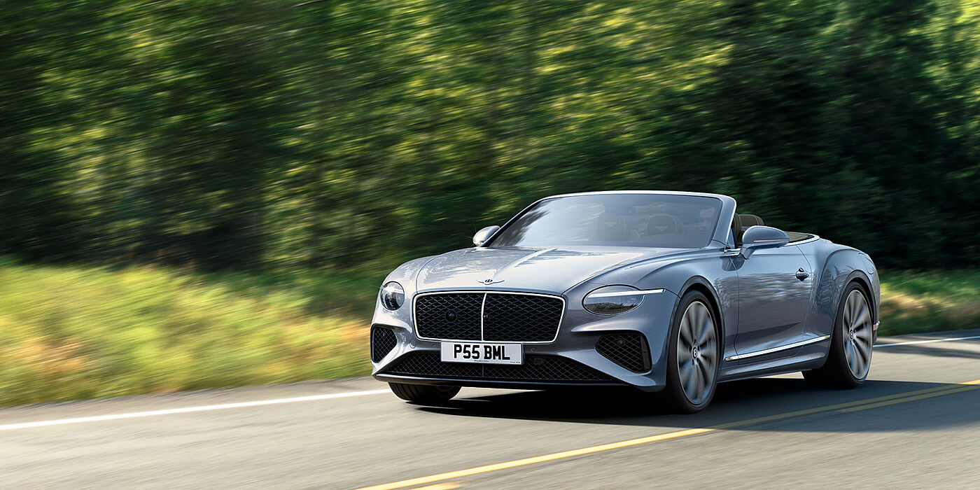 Bentley Surrey New Bentley Continental GTC convertible front view in Silverlake paint with 22 inch ten spoke wheels, driving dynamically on a country road