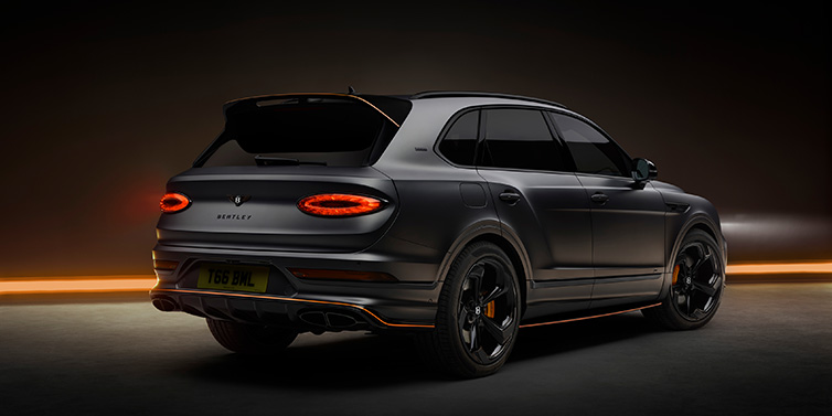 Bentley Surrey Bentley Bentayga S Black Edition SUV rear three quarter in Anthracite Satin paint against a dark red and yellow background