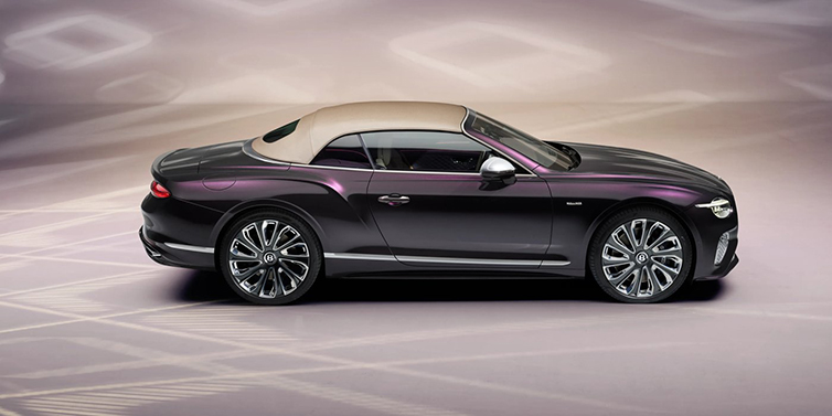 Bentley Surrey Bentley Continental GTC Mulliner convertible in profile with hood up, in Tanzanite Purple paint and 22 inch Mulliner painted and polished wheels