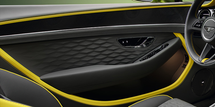 Bentley Surrey Bentley Continental GTC Speed convertible interior door details featuring Gravity Grey and Cyber Yellow by Mulliner hides and high gloss carbon fibre veneer