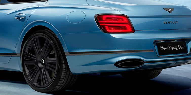 Bentley Surrey New Bentley Flying Spur Azure sedan in Light windsor blue by Mulliner paint and Black Specification, showing 22 inch Black Azure wheel, black exhaust pipes and exterior features