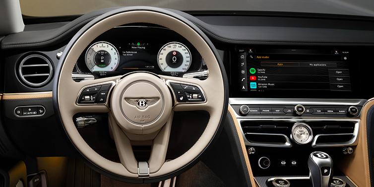 Bentley Surrey Bentley Flying Spur Mulliner sedan front interior detail of steering wheel and driver screens surrounded by Linen and Beluga black hides