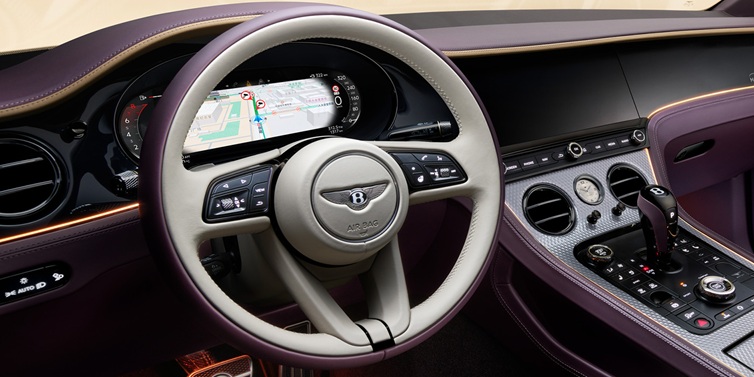 Bentley Surrey Bentley Continental GT Mulliner coupe front interior showing steering wheel and drivers screens surrounded by Linen and Damson hides and Grand Black veneer