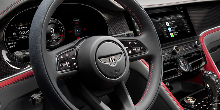 Bentley Surrey Bentley Flying Spur Speed sedan front interior detail showing steering wheel and driver screens surrounded with Hotspur red and Gravity Grey hides